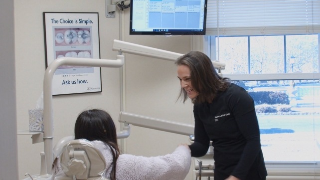 Dentist shaking hands with patient during preventive dentistry checkup and teeth cleaning
