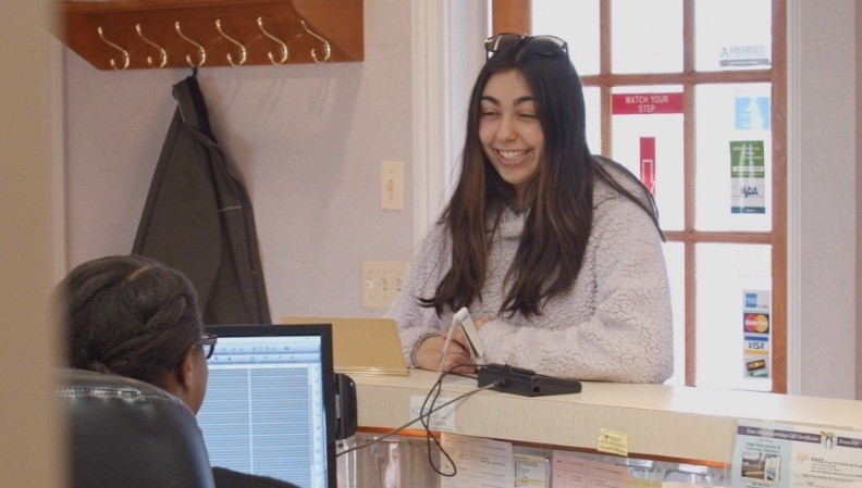 Smiling woman checking in at reception desk of Westfield New Jersey dental office