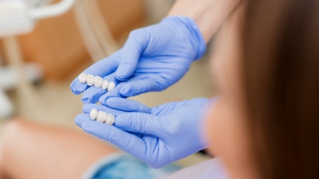 Dentist and patient looking at dental bridges together