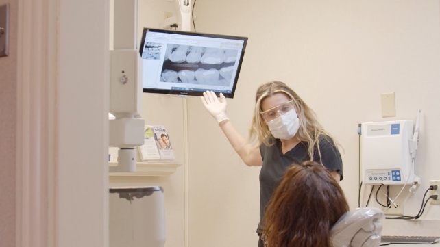 Dentist and patient looking at digital dental x-rays