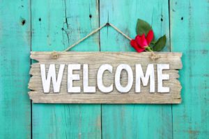 Cheerful welcome sign for dentist in Westfield, hung against blue background